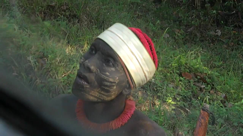 Jarawa férfit cukorral kínálnak egy busz ablakából.